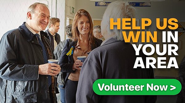 Party Leader Sir Ed Davey with other party members speaking to a volunteer.