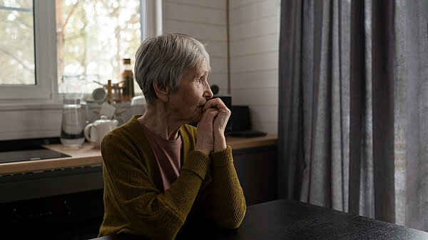 An elderly lady looking off into the distance.